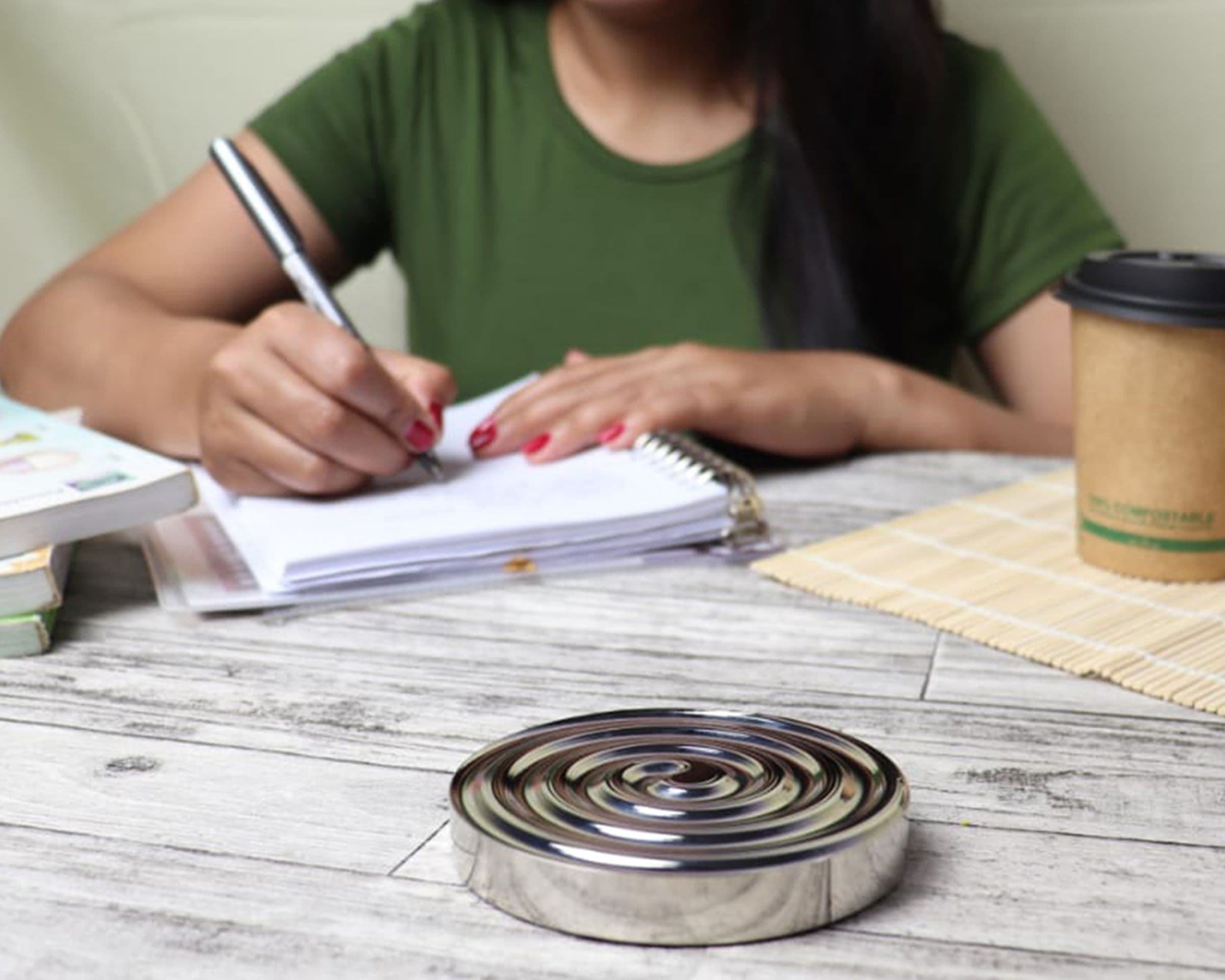 A woman writing in a notebook at a table