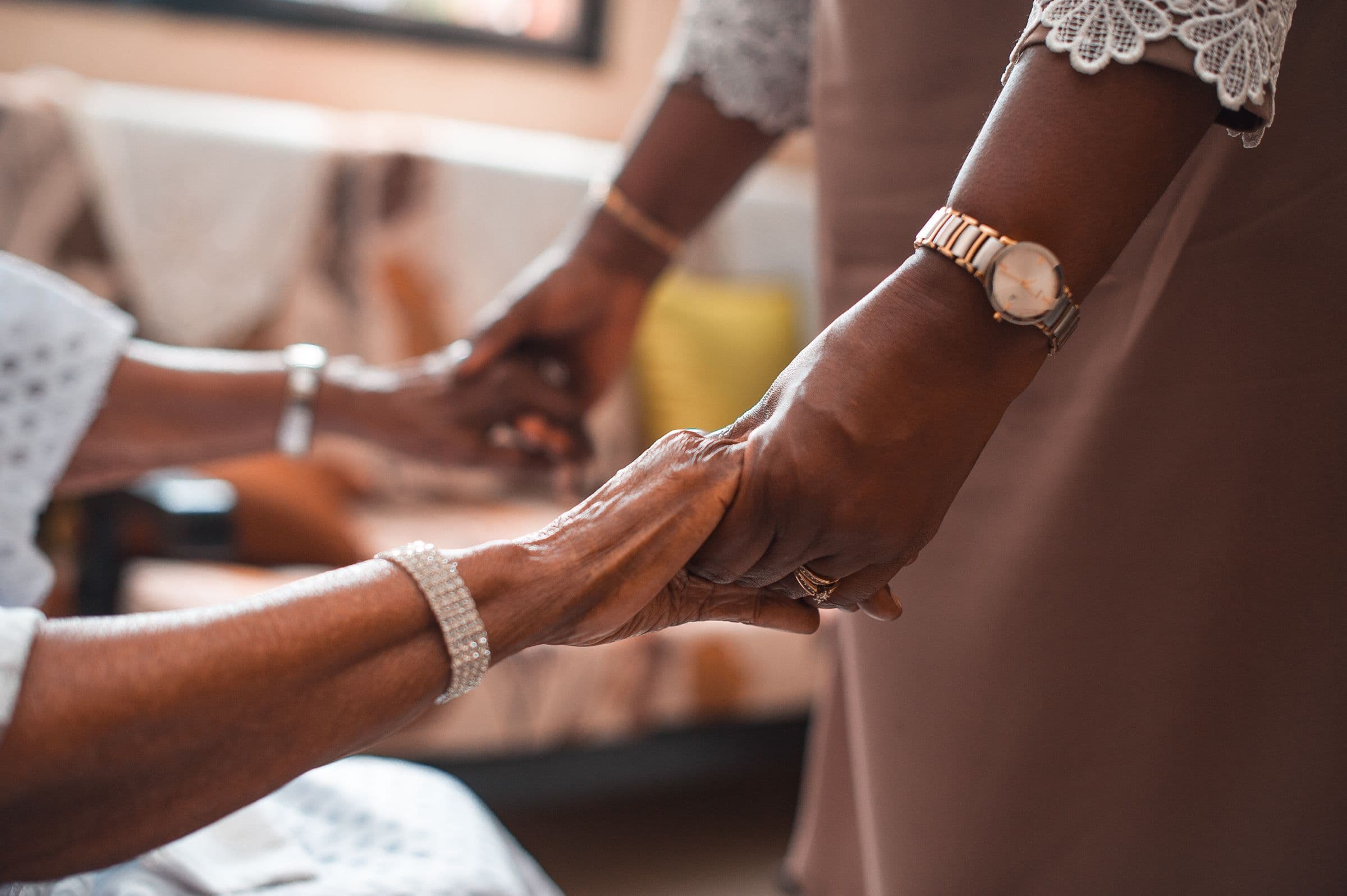 A woman holding the hands of an older woman